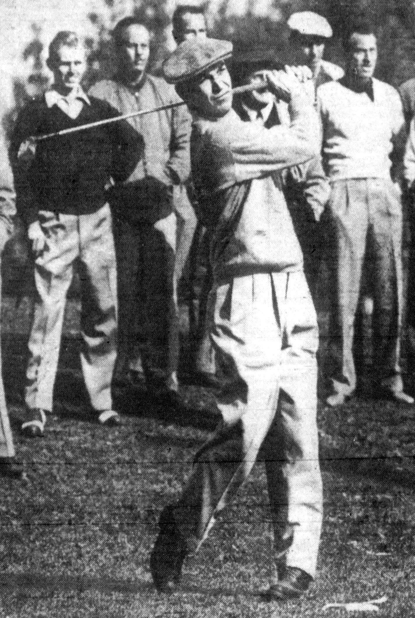 A golfer swinging a club in front of a small crowd, 1950s style