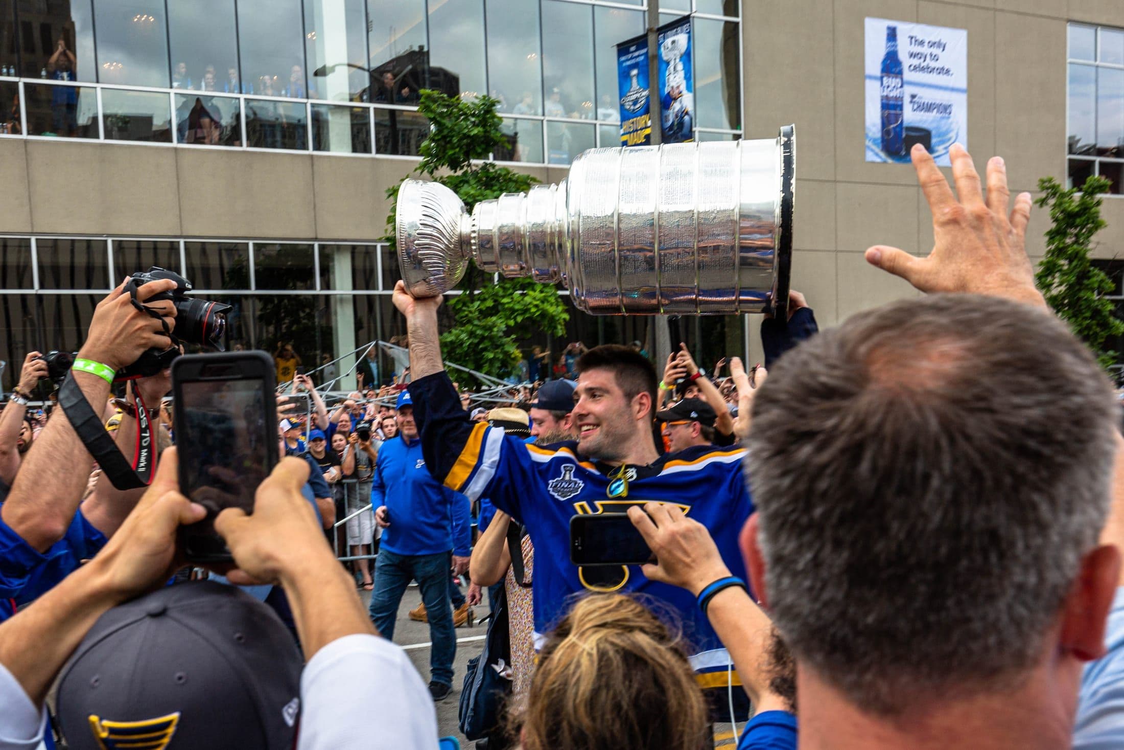 A St. Louis Blues player holding the Stanley Cup during the team's victory parade