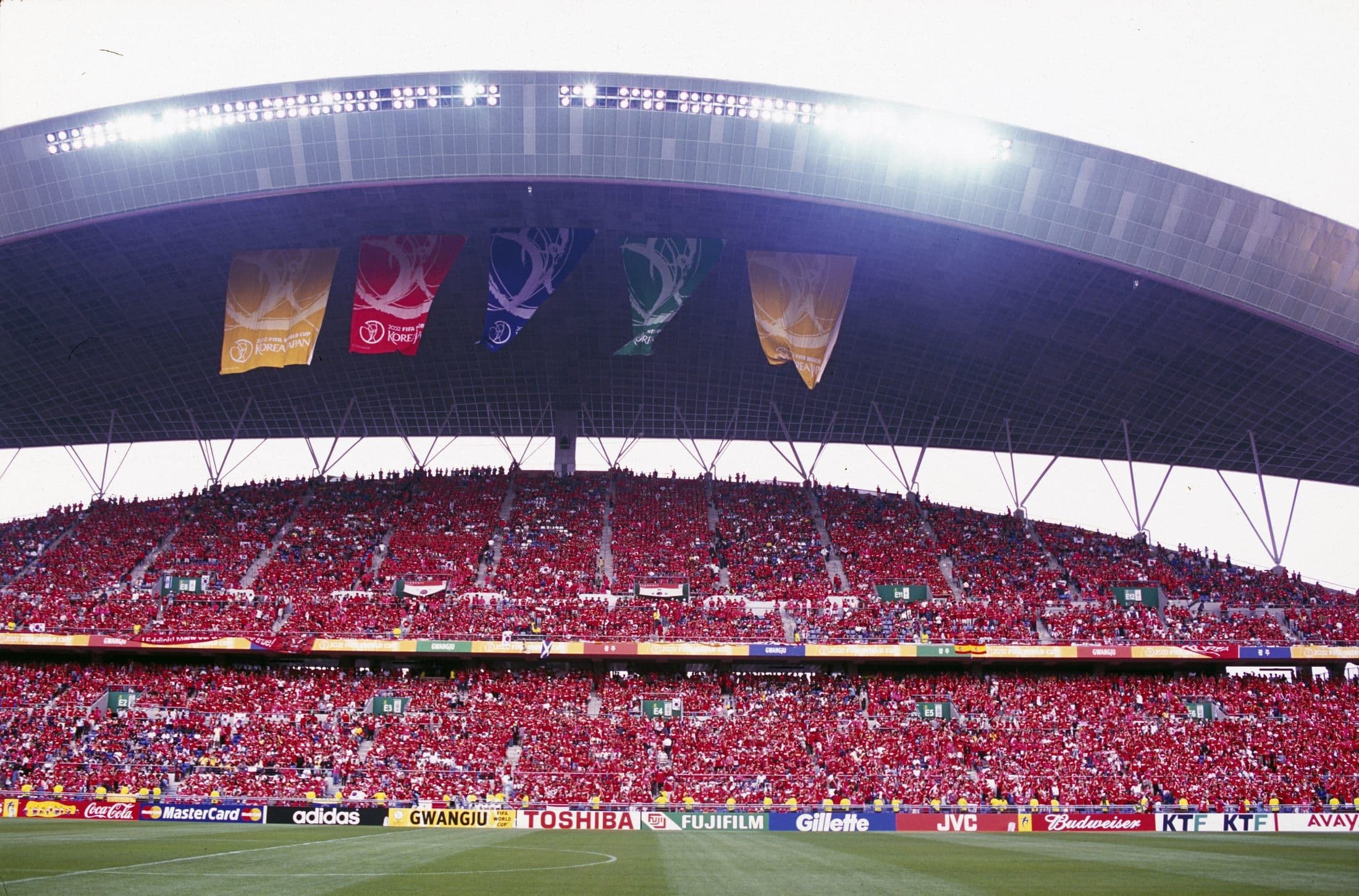 A packed stadium of red-shirted South Korean fans during the 2002 World Cup