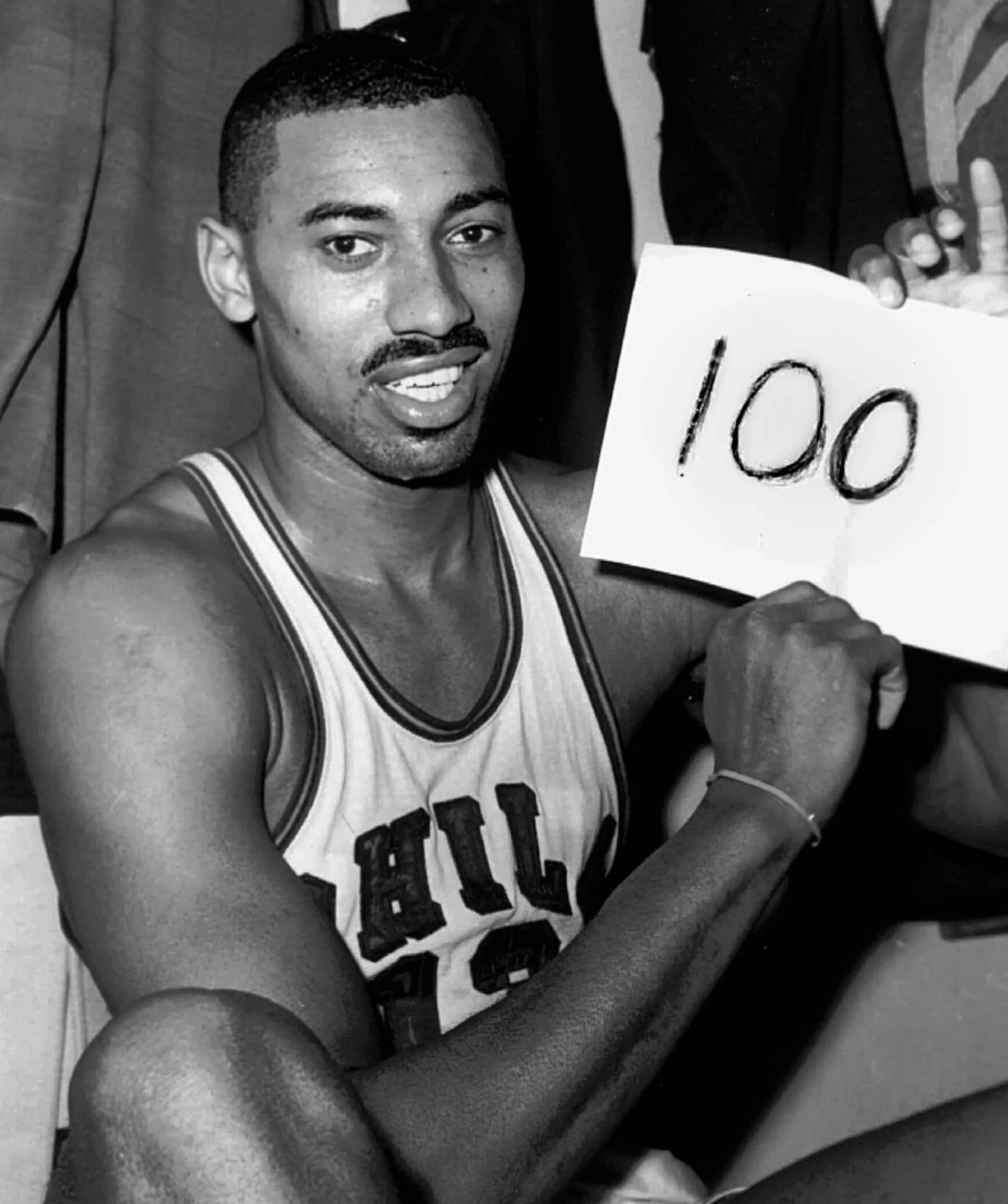 Wilt Chamberlain holding a sign reading '100' after his 100-point game